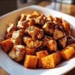 A bowl of BBQ Chicken Sweet Potato, featuring chicken and sweet potatoes coated in BBQ sauce.