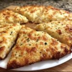 Close-up of sliced cheesy tortilla garlic bread, showcasing the melted cheese and garlic herb topping.