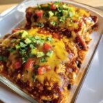 Delicious Chicken Cottage Cheese Enchilada in a glass baking dish, topped with melted cheese, avocado, and tomatoes.