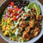 Overhead shot of a Chicken Taco Bowl with quinoa, corn, black beans, salsa, chicken, and lime.