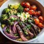A vibrant Healthy Steak Bowl with grilled steak, quinoa, roasted tomatoes, broccoli, and red onion.