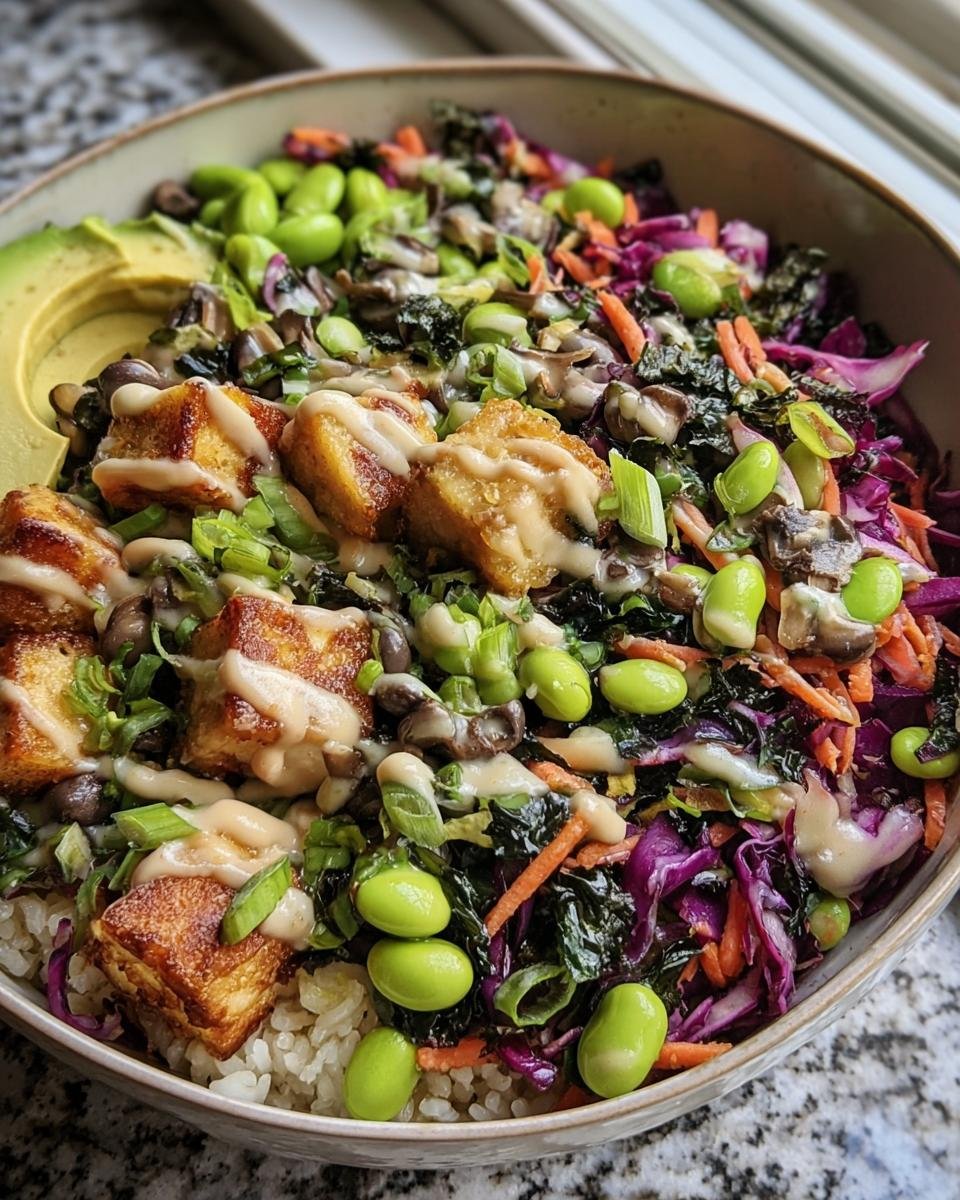 Close-up of a Longevity Miso Bowl with tofu, edamame, rice, avocado, and a creamy miso dressing.