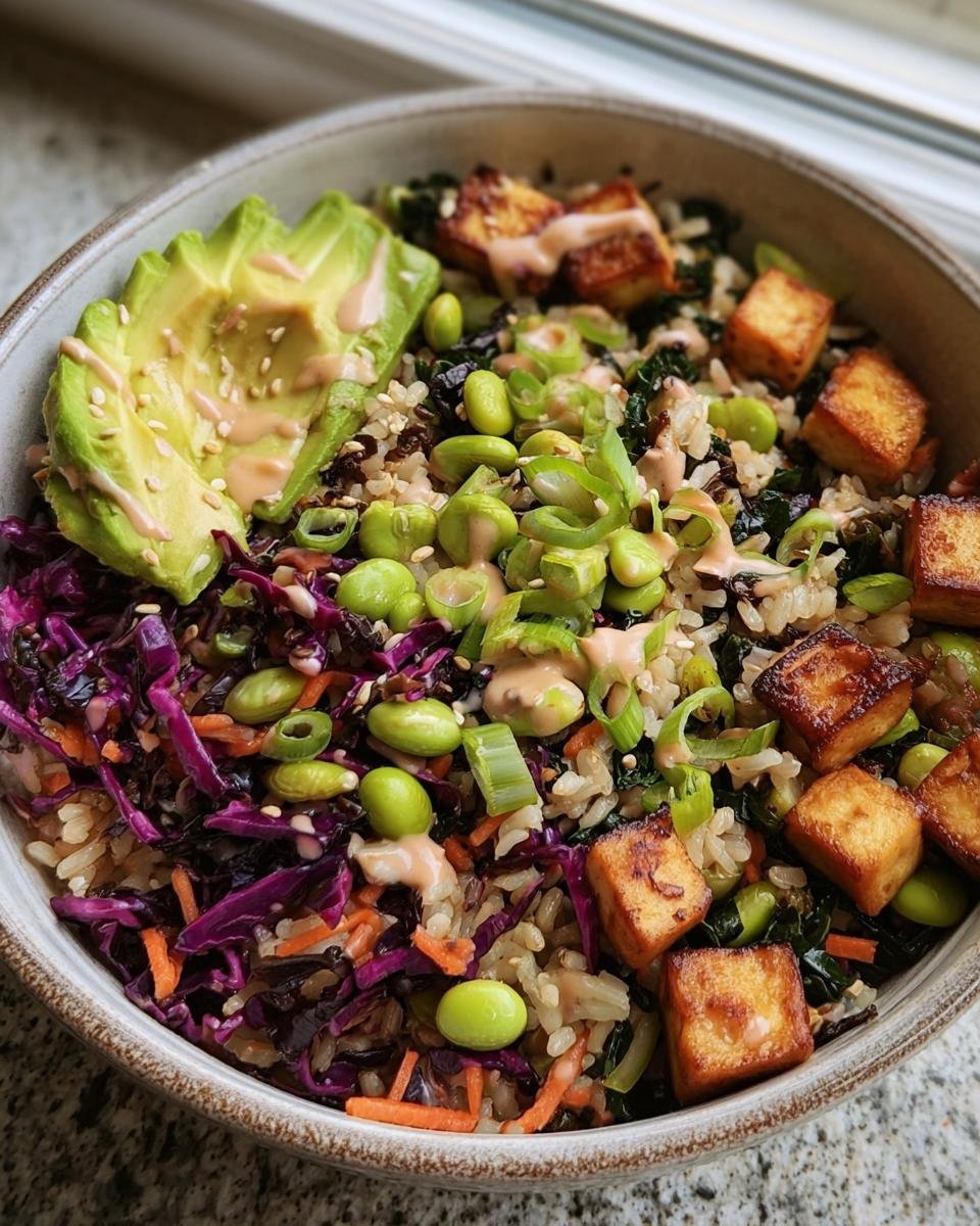 Close-up of a Longevity Miso Bowl featuring rice, tofu, avocado, edamame, cabbage, and a creamy miso dressing.