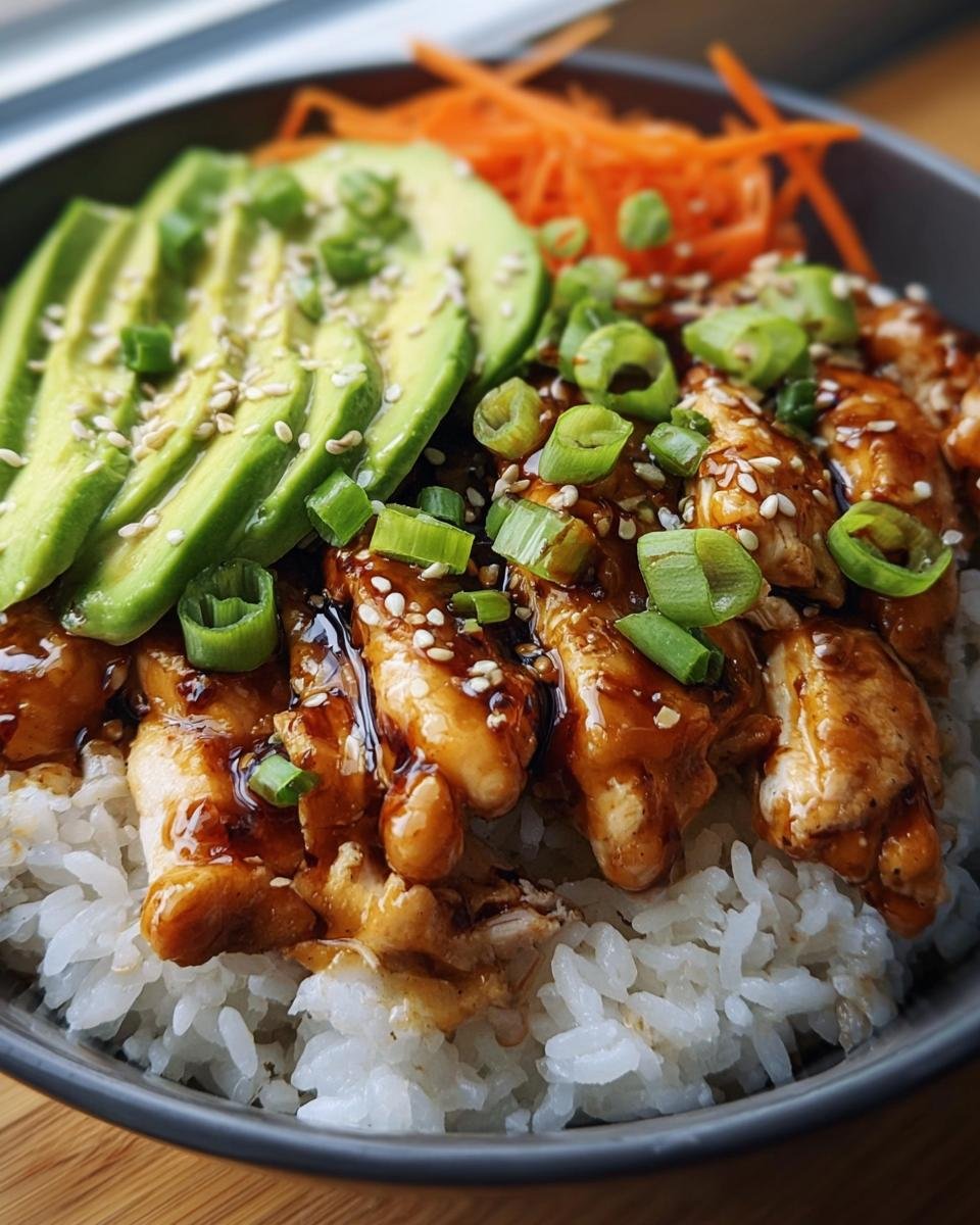 Close-up of a Teriyaki Chicken Avocado Rice Bowl with sesame seeds and green onions.