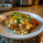 A serving of Chicken Cottage Cheese Enchilada on a white plate, garnished with green onions and cilantro.