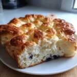 Close-up of a slice of Cottage Cheese Cloud Bread with blueberries on a white plate.