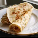 Two golden Cottage Cheese Wraps served on a white plate with a gold rim.