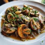 A plate of savory Cowboy Mushrooms sautéed with onions, simmered in sauce, and garnished with fresh parsley.