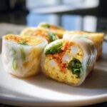 Close-up of Rice Paper Egg Wraps filled with egg, carrots, lettuce, and other fresh ingredients.