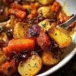 A close-up of gleaming Roasted Apples & Carrots, showing the caramelized texture and fresh herbs.