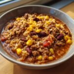 A close-up of a bowl of Taco Rice Soup, featuring ground beef, rice, corn, and kidney beans.