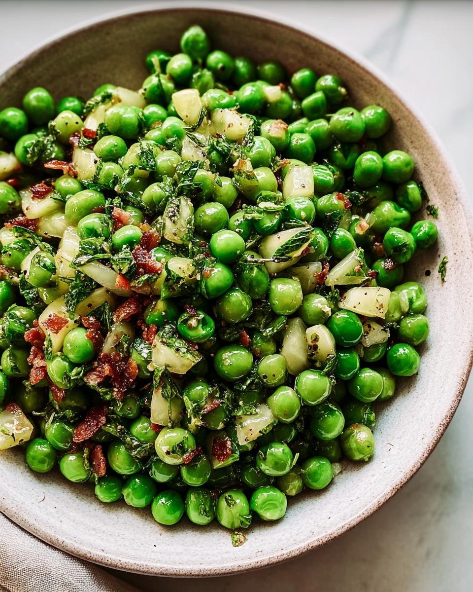 A bowl of vibrant Thanksgiving Peas with herbs, bacon, and onions, a perfect holiday side dish.