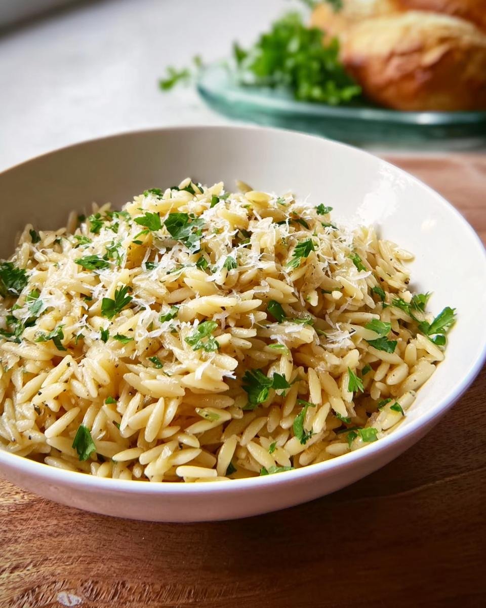 Close-up of a simple orzo pasta topped with grated Parmesan cheese and fresh parsley, perfect for a quick dinner.